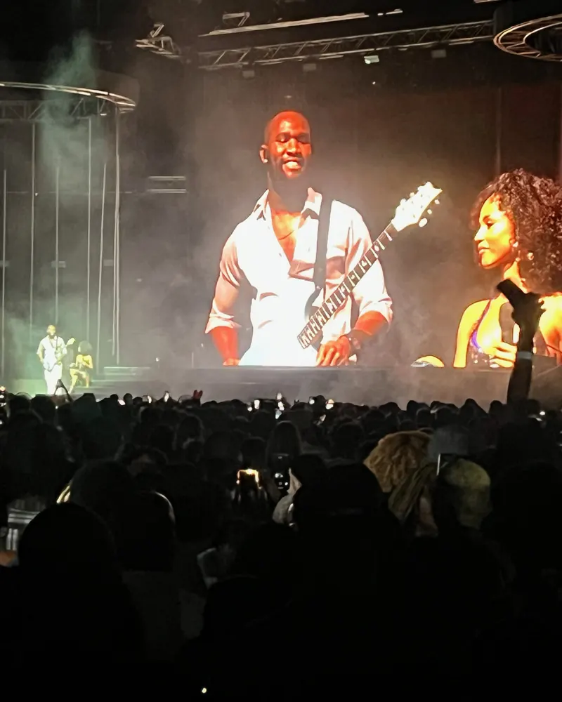 Iyke M Abu on the big screen at an arena show, with the crowd in front